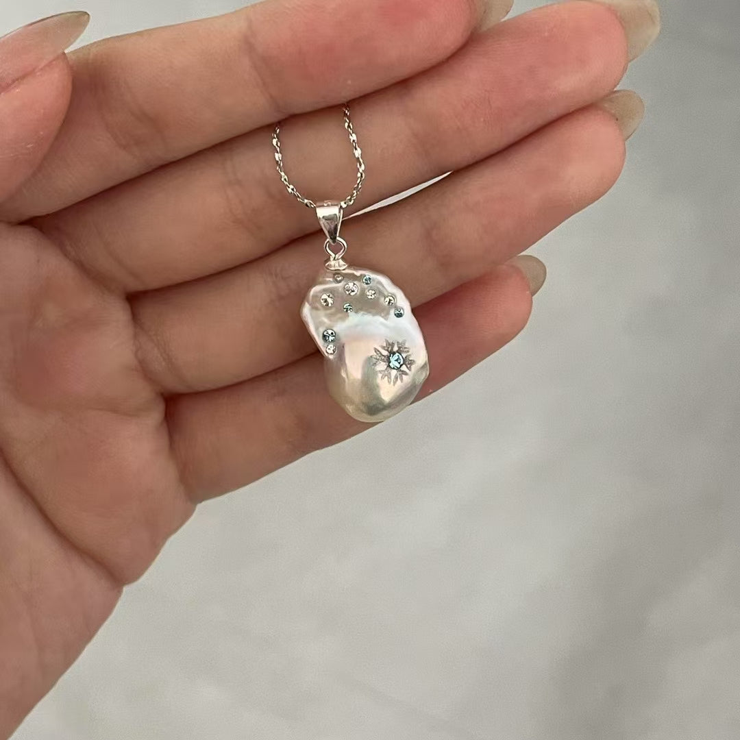 【Pearlish】First Flurries · Handcrafted inlaid and carved jewelry pendant featuring a natural freshwater baroque pearl set in a sterling silver base. A niche artisanal collectible, perfect as a gift.